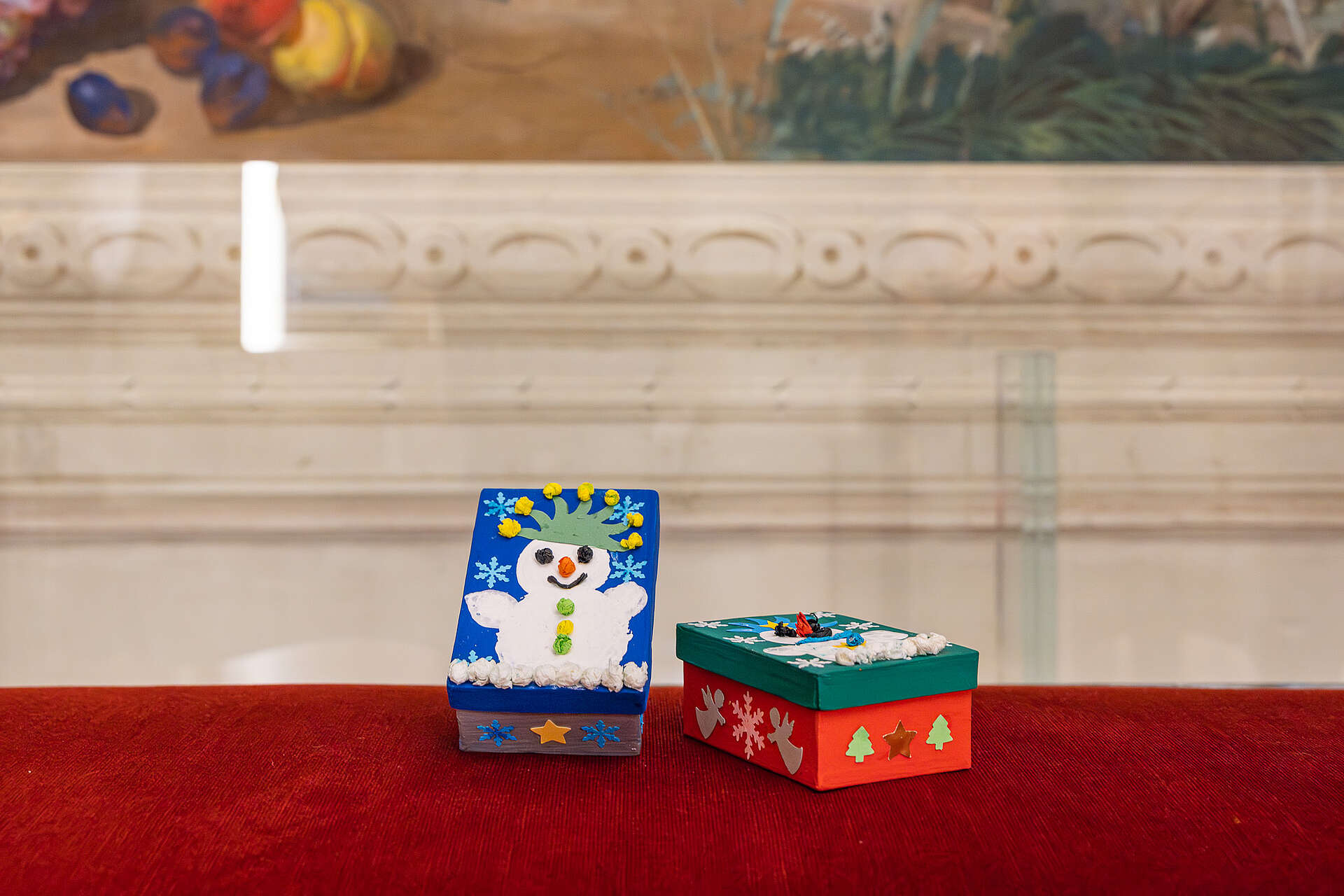 Selbstgebastelte Papierboxen mit bunten Motiven wie Schneemännern